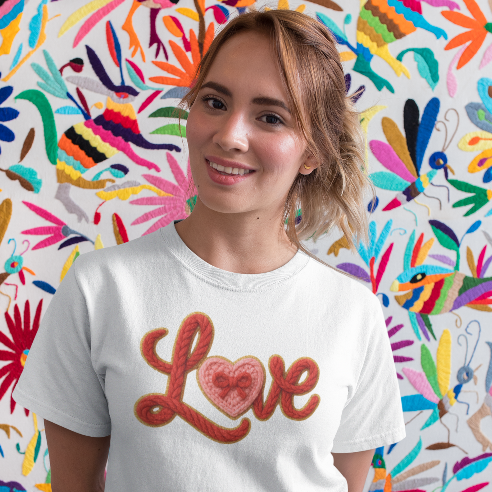 Person wearing a white t-shirt with 'Love' printed on it, standing in front of a colorful abstract wall.