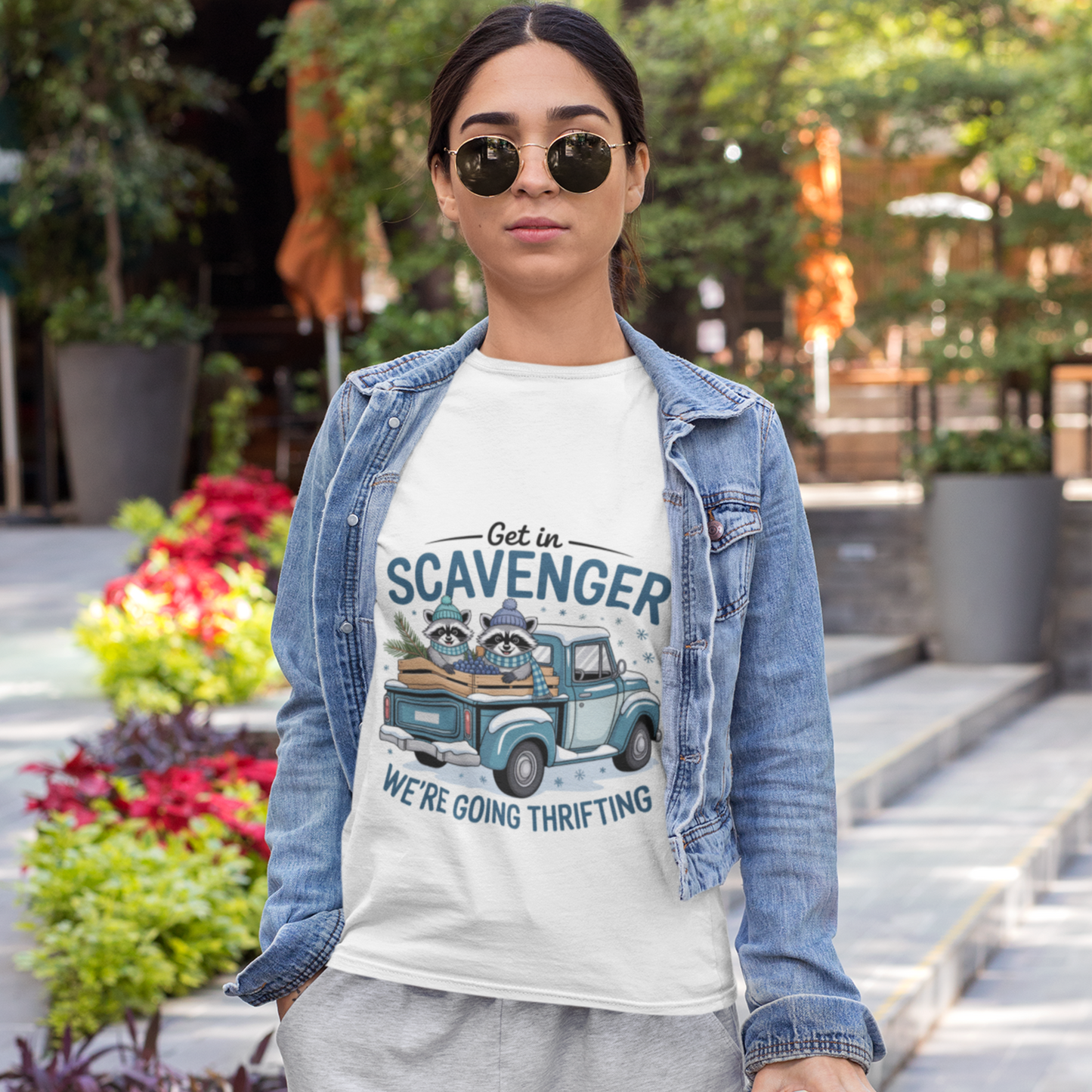 Woman wearing a t-shirt with a graphic design and text, standing outdoors.
