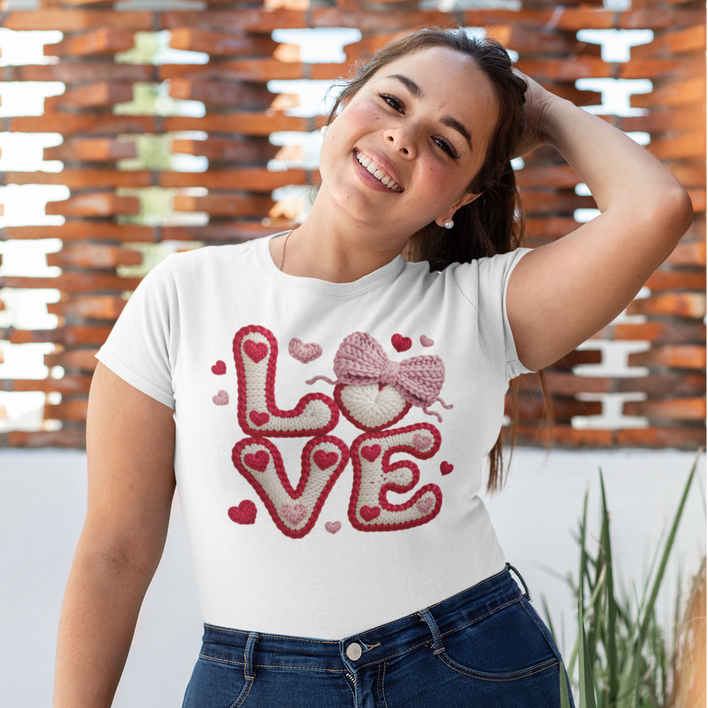 Woman wearing a white t-shirt with a red 'LOVE' design outdoors.