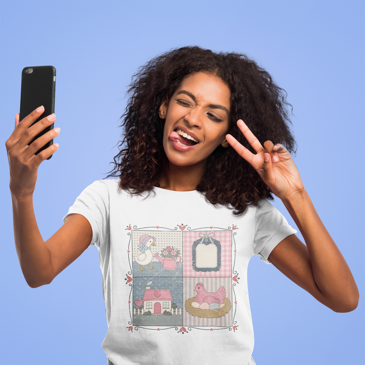 Woman wearing a t-shirt with a graphic design, taking a selfie against a blue background